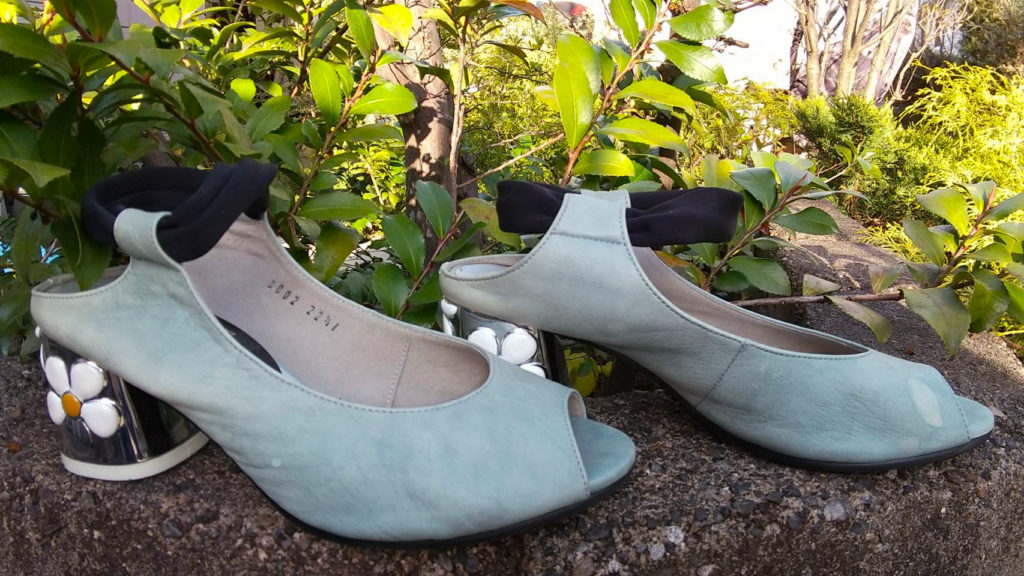草木の緑に水色が映える花のモチーフがついた婦人靴